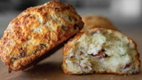 cross section of a savory scone on a wooden surface with a blurred background
